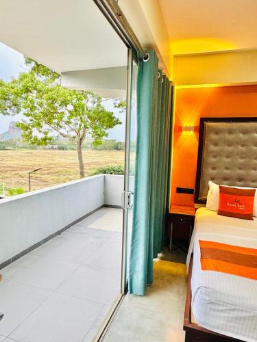 a bedroom with a balcony with a bed and a window at Royal Rock Sigiriya in Sigiriya