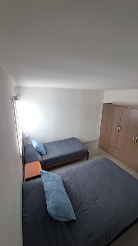 a room with two beds and cabinets in it at Hospedaje - Apart Hotel Las Higueras Talcahuano in Talcahuano