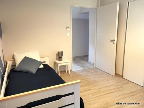 a bedroom with a bed and a room with a door at Gîte de Charme avec Terrasse Privative et Grand Jardin près du Parc Le Pal - FR-1-489-339 in Thiel-sur-Acolin