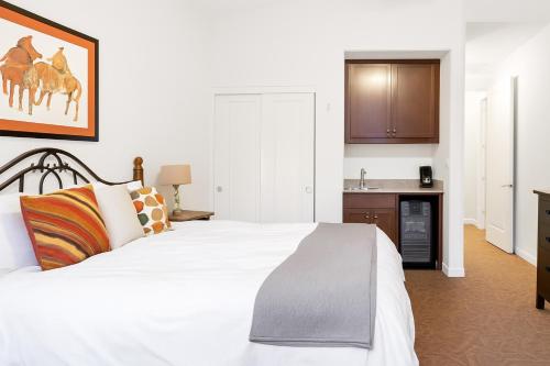 een slaapkamer met een wit bed en een keuken bij La Quinta Studio Suite, Fp, Views, Patio in La Quinta