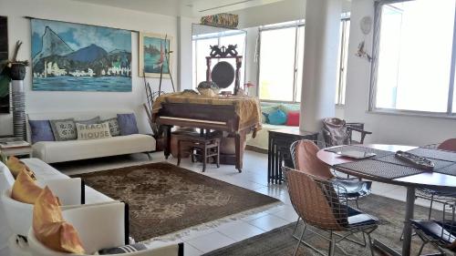 sala de estar con mesa y piano en Ocean apartment, en Río de Janeiro