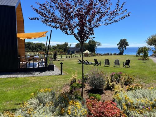 ogród przed domem ze stołem i krzesłami w obiekcie LAVANDA CABAÑA BOUTIQUE a ORILLA LAGO LLANQUIHUE w mieście Llanquihue