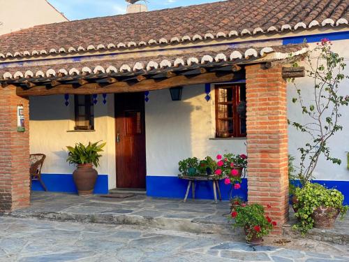 a blue and white house with a porch with flowers at Casa Mira in Montes Juntos