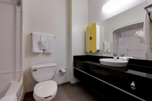 a bathroom with a white toilet and a sink at Studio 6 Toronto - Mississauga with Kitchenettes in Mississauga