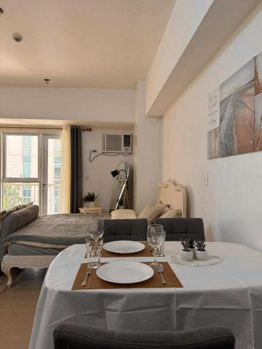 a living room with a table with plates and wine glasses at Venice Vista Lodge Staycation near Venice Grand Canal in Manila