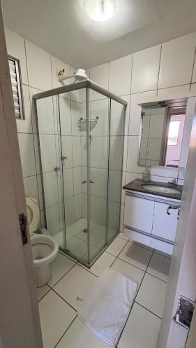 a bathroom with a glass shower and a toilet at Apartamento Veneza in Franca