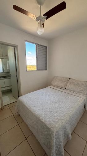 a bedroom with a bed and a ceiling fan at Apartamento Veneza in Franca