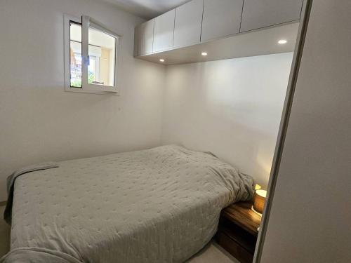 a small bedroom with a bed and a window at Ravissant T2 aux Issambres avec Piscine et Climatisation - FR-1-768-126 in La Garonnette-Plage