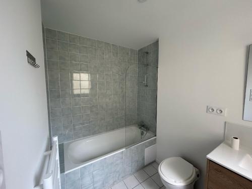 a bathroom with a tub and a toilet and a sink at Maison près de la plage pour 6 pers. avec WiFi - FR-1-197-638 in Les Sables-dʼOlonne