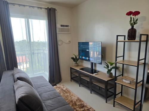 a living room with a couch and a television at VERDANT by Vista Manors Deluxe Rooms with Balcony, Gym and Swimming Pool in Puerto Princesa City