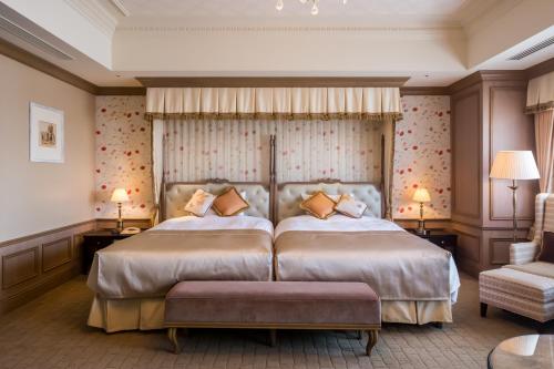 a bedroom with a large bed and a couch at Hotel Monterey Grasmere Osaka in Osaka