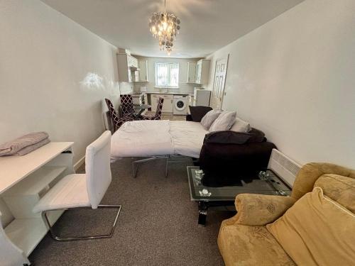 a living room with a bed and a couch at The Flat in Monmore Green
