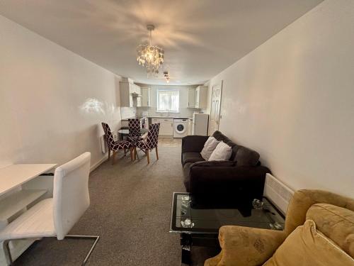 a living room with a couch and a table at The Flat in Monmore Green
