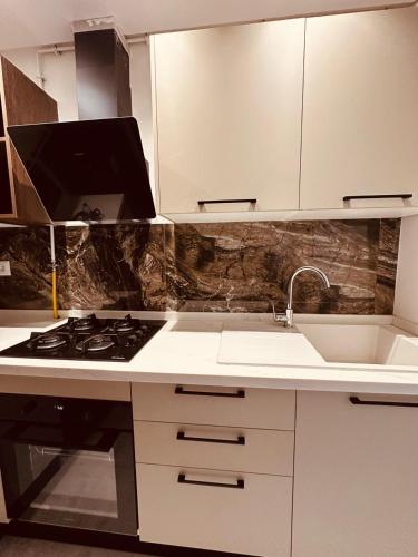 a kitchen with a stove and a sink at Luxueux S1 nouvelle Soukra in Tunis