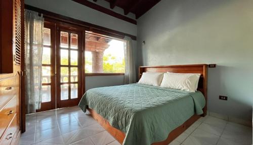 a bedroom with a bed and a large window at Casa Zaragoza in Valle de Bravo