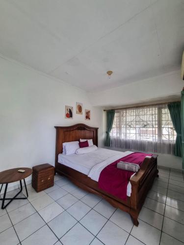 ein Schlafzimmer mit großem Bett und Fenster in der Unterkunft Villa Pesona Merapi With 3 BR in Ngaglik