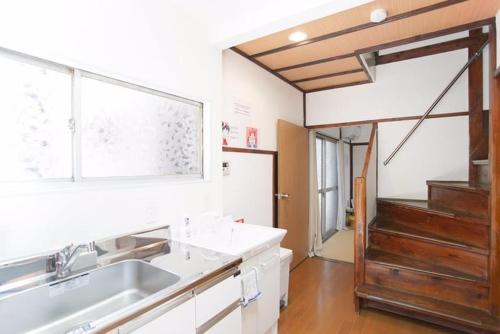 a kitchen with a sink and a window and a staircase at 4mins from sky tree Sumida area 3rooms Wifi in Tokyo