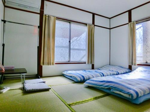 two beds in a room with two windows at 4mins from sky tree Sumida area 3rooms Wifi in Tokyo