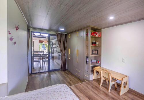 a room with a bed and a table and a dining room at Cocohome Đà Lạt - Villa & Homestay Best Price in Ấp Ða Lợi