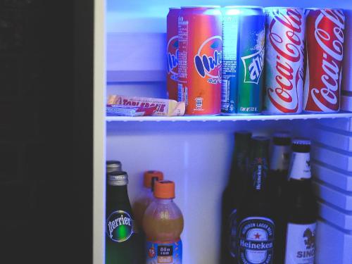 a refrigerator filled with drinks and cans of soda at Art Mai Gallery Nimman Hotel Chiang Mai in Chiang Mai