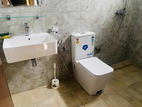 a bathroom with a white toilet and a sink at Blue Star Apartments three bedroom apartment in Dehiwala
