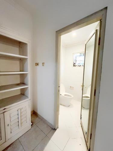 a bathroom with a toilet and a sink and a mirror at Villa Pesona Merapi With 3 BR in Ngaglik
