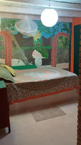 a bed in a room with a painting on the wall at Estância Verde in Valença