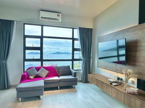 a living room with a couch and a large window at Jesselton Quay Kota Kinabalu City Centre by LW Suites in Kota Kinabalu