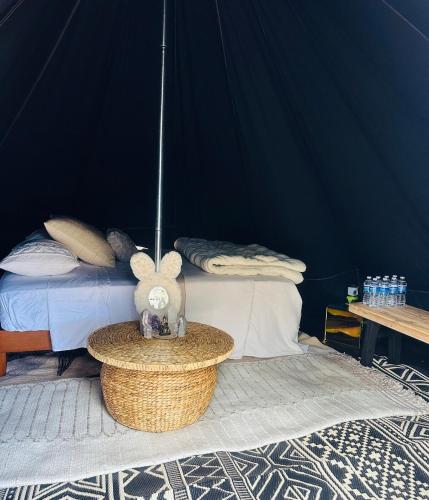 a bedroom with a bed and a table with a stuffed animal at Rocky Ridge Glamping Yosemite in Coarsegold