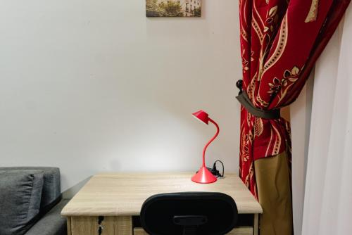 a table with a red lamp on it next to a curtain at Nottingham Villa in Puerto Princesa