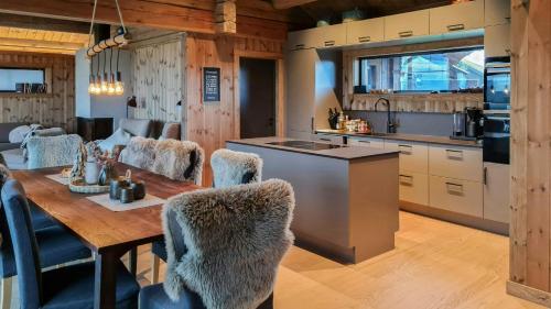 a kitchen and dining room with a table and chairs at Modern Family Cabin Near Kikut In Geilo in Flatåker