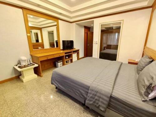a hotel room with a bed and a mirror at New Siya in Maha Sarakham