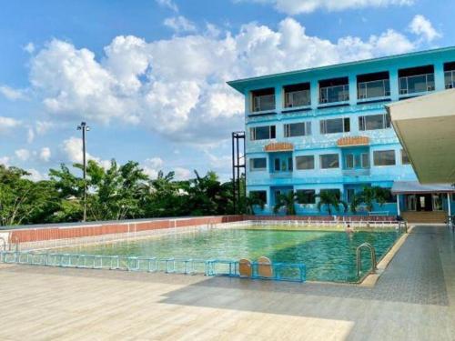 a building with a swimming pool in front of a building at New Siya in Maha Sarakham