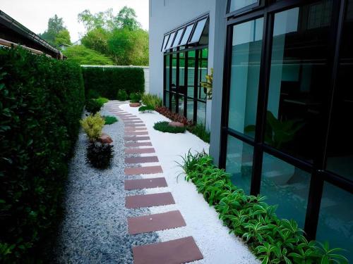 a garden with rocks and plants next to a building at @Sleep in Nakhon Pathom