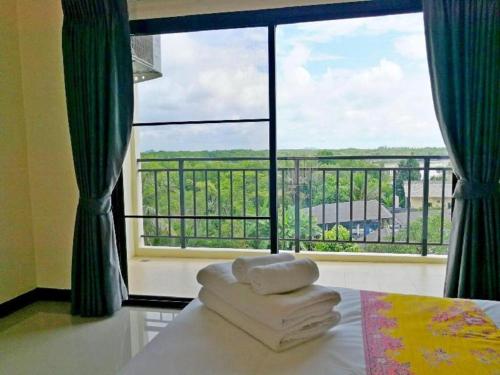 a room with a large window with towels on a table at The Nest Krabi Hotel in Ao Nang Beach