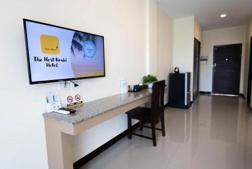 a room with a counter with a tv on the wall at The Nest Krabi Hotel in Ao Nang Beach