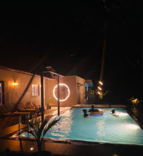 a group of people in a swimming pool at night at Ramya Ru Nature Resort in Galle