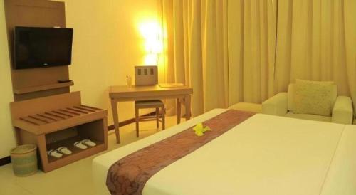 a hotel room with a large bed and a television at Patra Cirebon Hotel & Convention in Cirebon