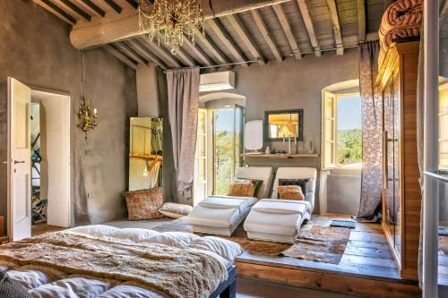 a bedroom with a large bed and a chandelier at Tuscan Country House With Pool And Spa in Capolona