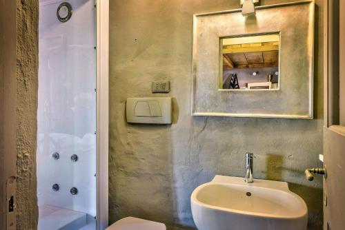 a bathroom with a sink and a toilet and a mirror at Tuscan Country House With Pool And Spa in Capolona