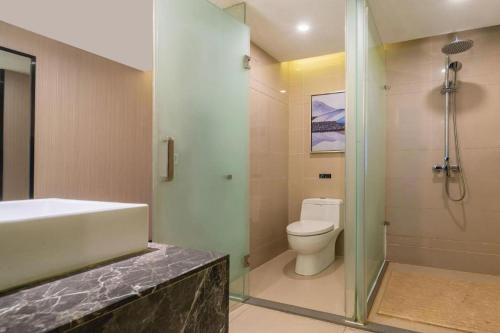 a bathroom with a shower and a toilet and a sink at Echarm Hotel Yingshang High-speed Railway Station Wuzhou Wanhui Plaza in Fuyang