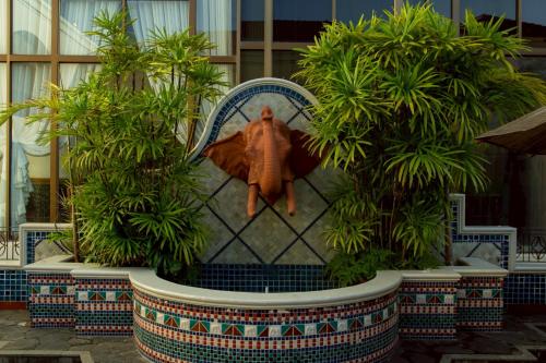 a statue of a bug sitting on a chair with plants at CS Pattani Hotel in Ban Ru Sa Mi Lae