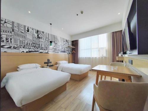 a hotel room with two beds and a desk at City Comfort Inn Xiaogan Xiaochang Bus Passenger Station in Xiaogan
