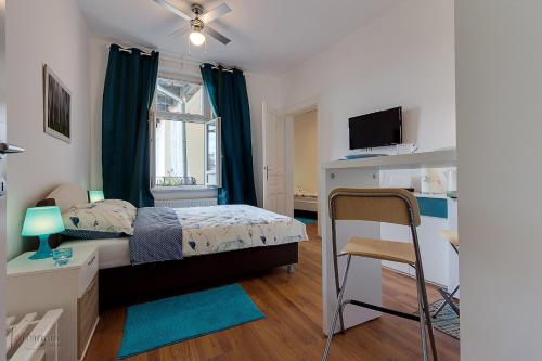 a bedroom with a bed and a desk and a window at George Apartment in Zagreb