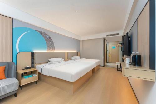 a bedroom with a large white bed and a chair at City Comfort Inn Shiyan Wudang Mountain in Danjiangkou