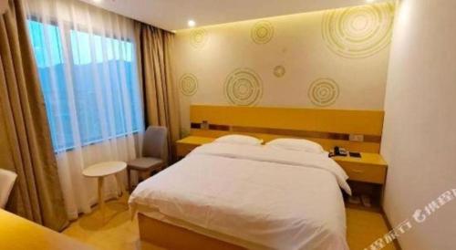 a hotel room with a bed and a window at GreenTree Inn Linhai Jiangnan Avenue Express in Linhai