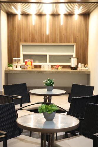 a restaurant with two tables and chairs and a counter at Hotel 1140 in Linares