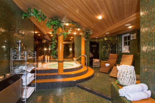 Hotel Chalet Olympia في مونغيلفو: حمام مع حوض جاكوزي في مبنى
