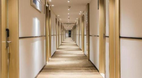 an empty hallway in a building with a long aisle at City Comfort Inn Kunshan Development Zone Penglang Xinxing Middle Road in Suzhou