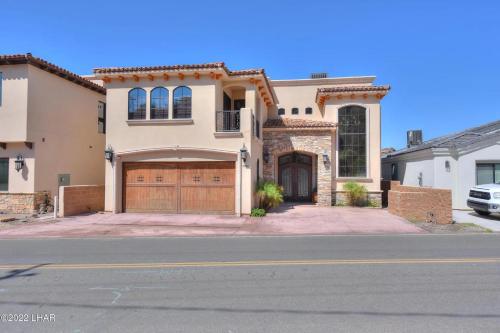 a large house with a garage on a street at Splash Landing! Dock, Pool & Hot Tub , Riverfront House & Guest in Cienega Springs